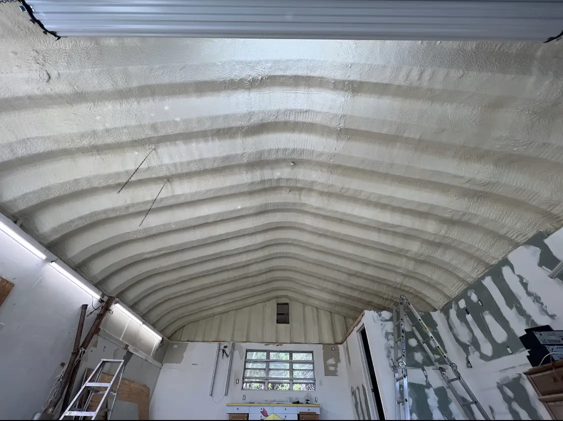 Spray polyurethane foam applied to the underside of a metal roof deck in Dumont
